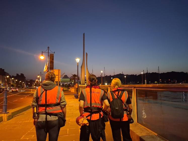 Three volunteers walking the Mall at dusk
