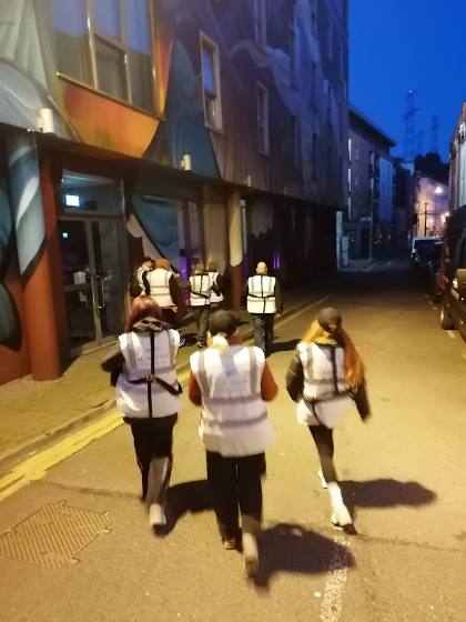 Volunteers walking a city street at night