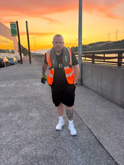 A volunteer in a lifejacket on the Greenway at sunset