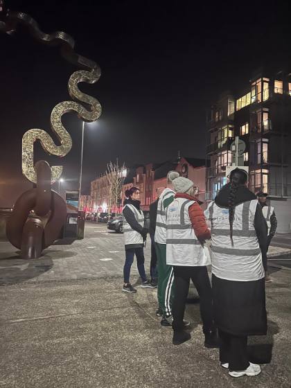 Volunteers gathered by the chain sculpture at night
