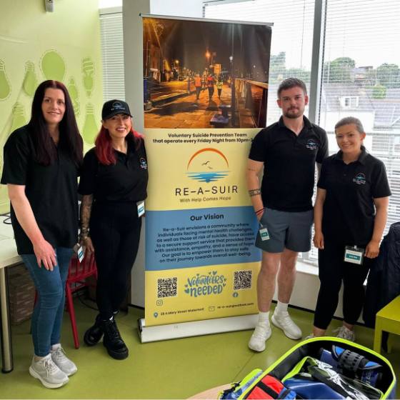 Four team members beside a Re-A-Suir banner