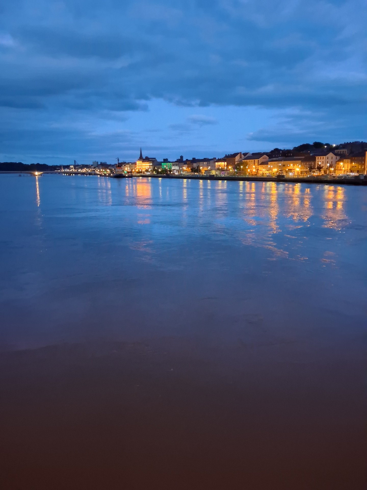 Waterford City and the River Suir lit up at dusk, seen from across the water